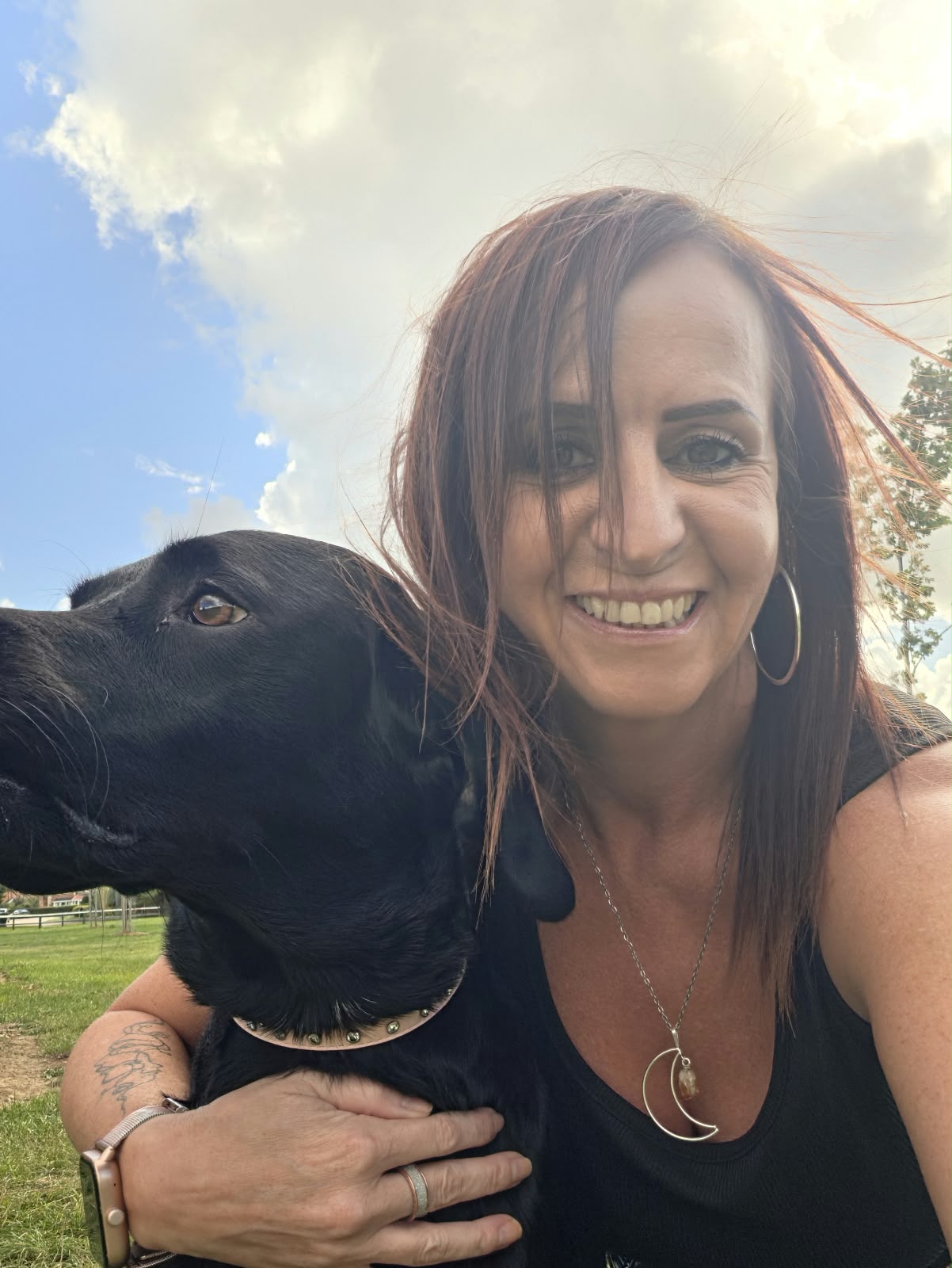 Kelli embracing her dog Harley in a park